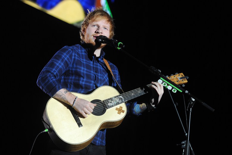 SEO-Friendly Alt-Text: Ed Sheeran playing acoustic guitar on stage during a concert performance in Prague, Czech Republic.