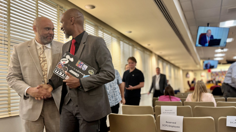 Michael Smith, principal of Baldwin Middle-Senior High School, left, shakes a colleague's hand.
