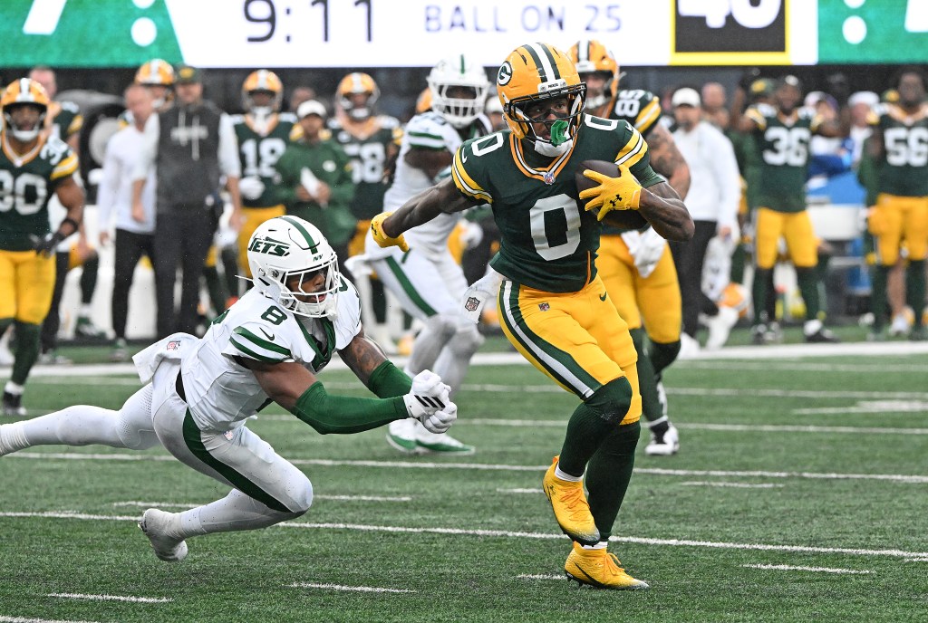 Green Bay Packers wide receiver Matthew Golden #0 runs the ball and stiff-arms New York Jets safety Andre Cisco #8.