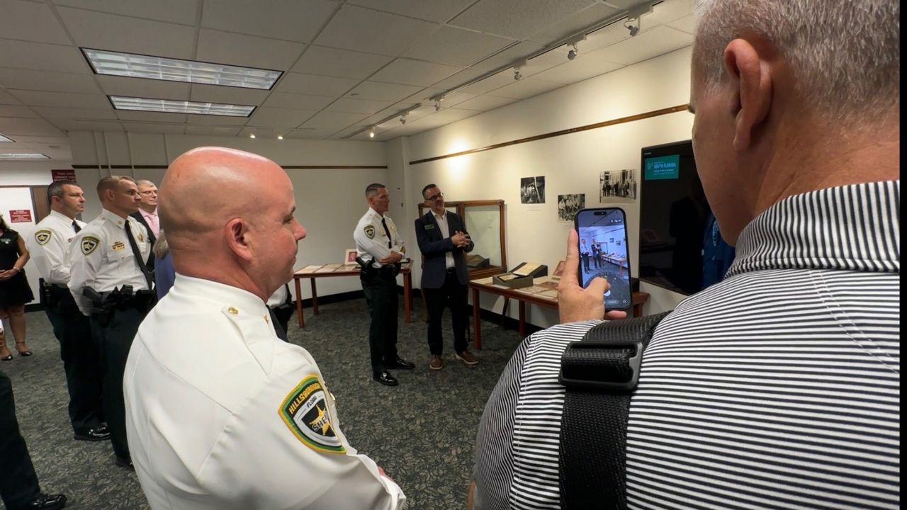 Sheriff Chad Chronister and USF Professor Davide Tanasi talk at an event unveiling the collection. (Spectrum News/Jeff Butera))