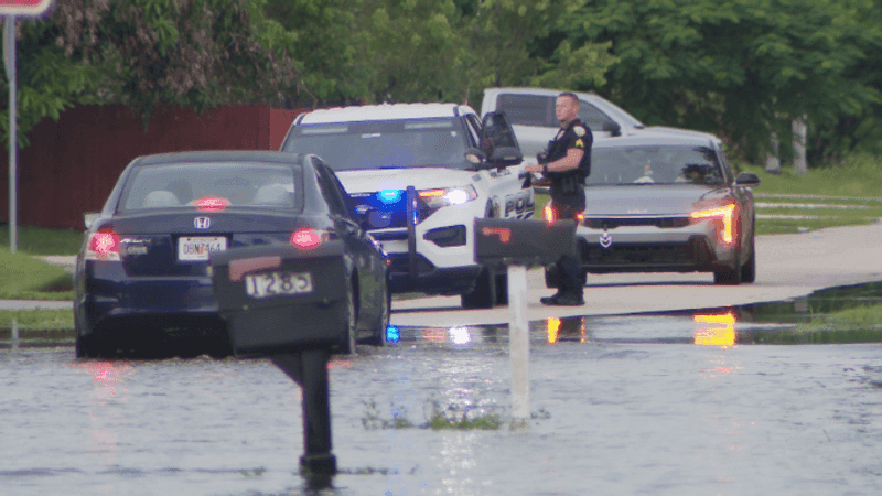 A Port St. Lucie police officer monitors traffic and flooded streets near Crosstown Parkway as crews worked to keep drivers safe during Tuesday's flooding. (WPEC)