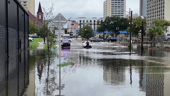 Some areas of Downtown Jacksonville see flooding; JSO officer helps push car out of water