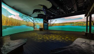 photo of a room inside a museum with two wall-sized LED screens depicting the Everglades