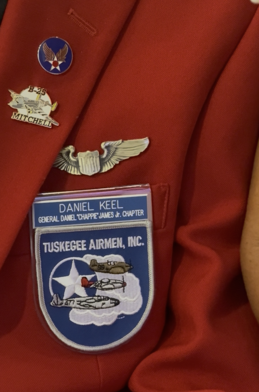 A close-up shot of military insignia on a red blazer worn by Tuskegee pilot Daniel Keel.