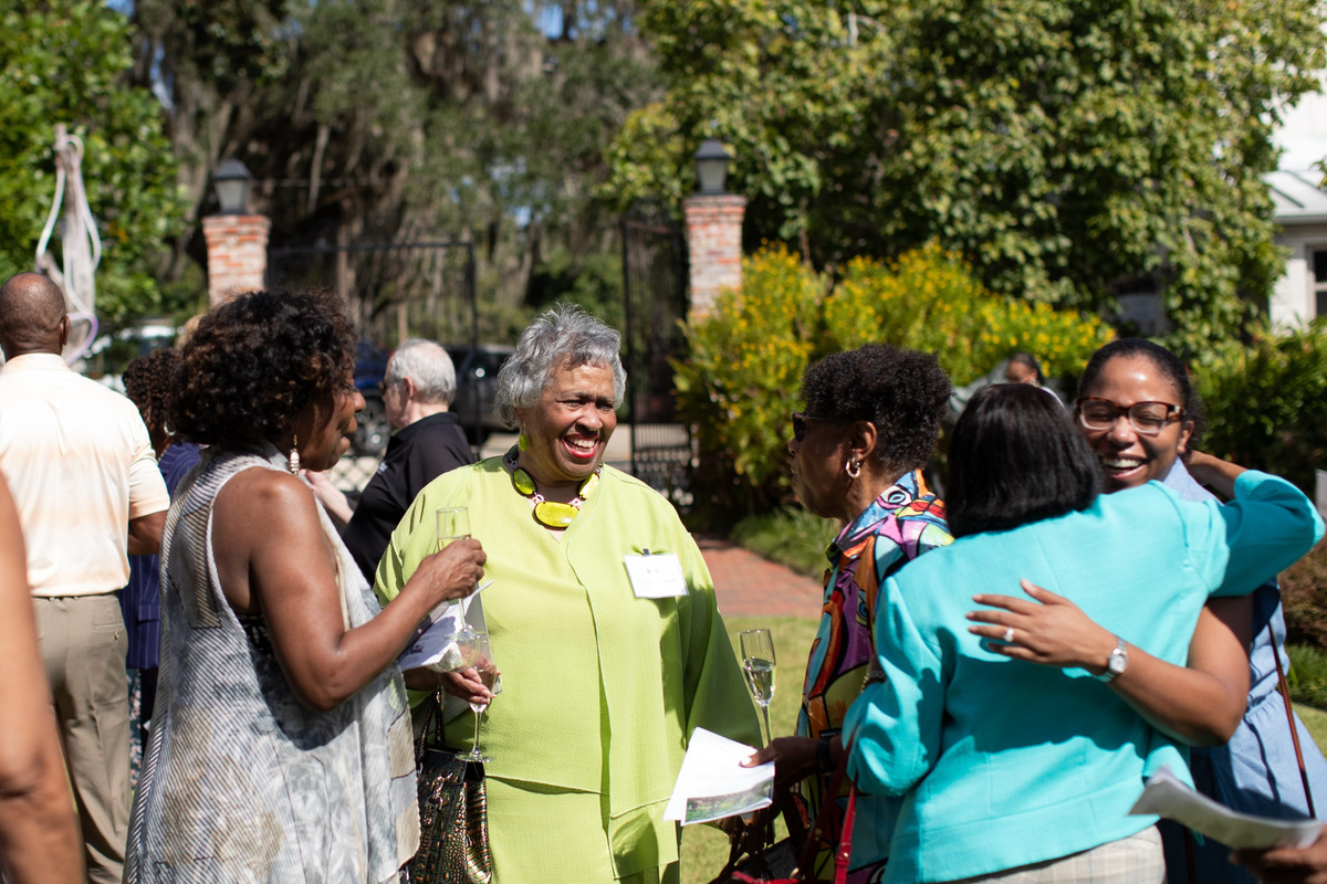 Linda G. Dilworth talks with attendees as two women embrace outside prior to a toast during the Oct. 1 LeMoyne Arts African American Tribute Garden Dedication Ceremony.