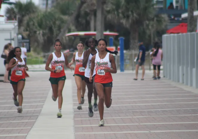 Mandarin's Jaymie Vedia (3804), Luna Crane (3791), Marlee Munn (3798) and Angelina Robinson (3801) and Raines' Calleigh Buchanan (3809) race to the girls finish line during the Nor'Eastern Classic high school cross country meet on Sept. 29, 2026 in Jacksonville Beach, Florida. [Clayton Freeman/Florida Times-Union]