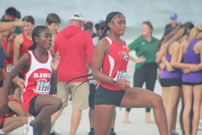 Jackson's Sanyia Randolph (3720) and Zoriah McQueen (3717) warm up before the Nor'Eastern Classic high school cross country meet on Sept. 29, 2026 in Jacksonville Beach, Florida. [Clayton Freeman/Florida Times-Union]