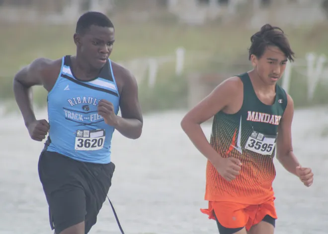 Ribault's Curtis Green (3620) and Mandarin's Samuel Rivera (3595) run in the boys race during the Nor'Eastern Classic high school cross country meet on Sept. 29, 2026 in Jacksonville Beach, Florida. [Clayton Freeman/Florida Times-Union]