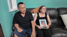 Jennifer Arias’ parents, Wilson and Monica, holding a photo of their daughter and granddaughter, Jenella.
