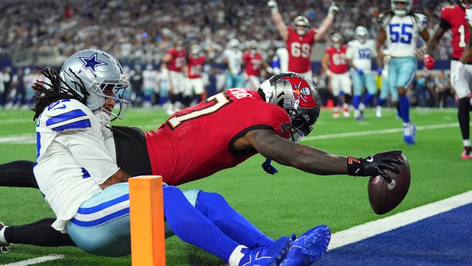 Tampa Bay Buccaneers running back Bucky Irving (7) dives past Dallas Cowboys defensive back Reddy Steward (27) for a touchdown in the first half of an NFL football game in Arlington, Texas on Thursday, Oct. 8, 2026. (AP Photo/Julio Cortez)