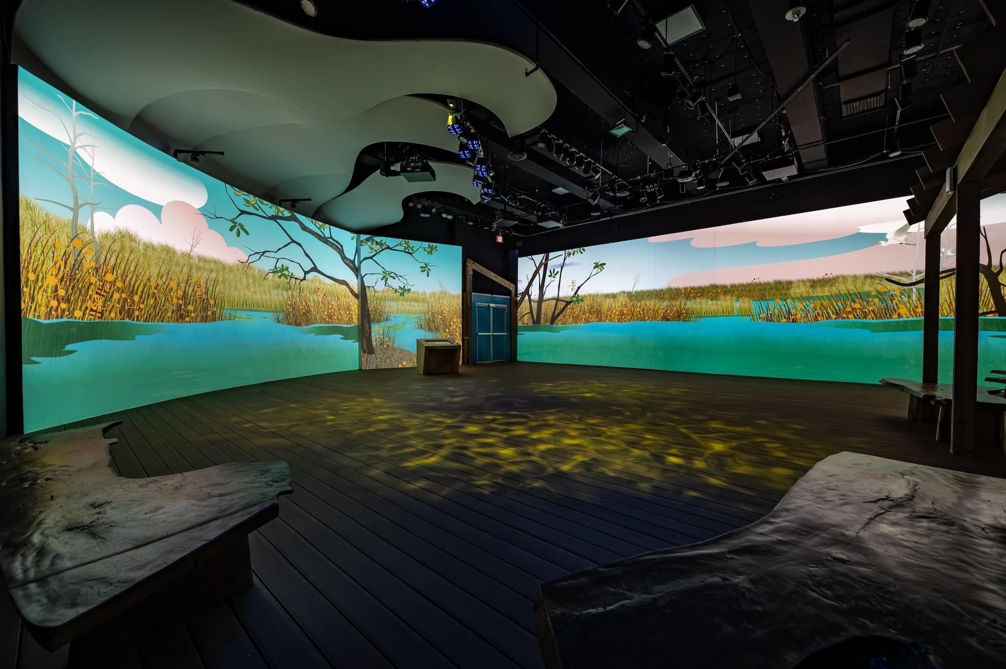 photo of a room inside a museum with two wall-sized LED screens depicting the Everglades