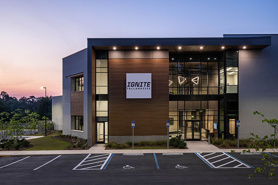 A view at the front of a building with a sign reading "IGNITE Tallahassee" during sunset.