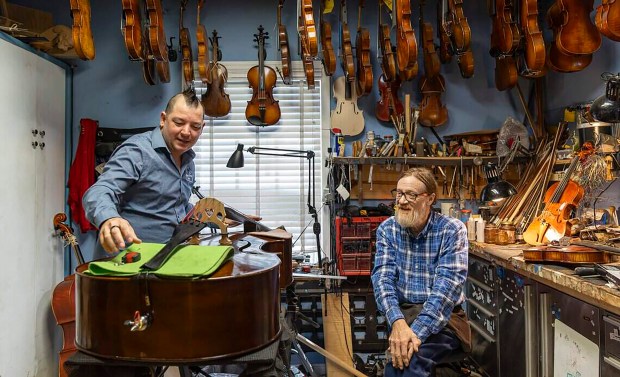 Miami String Haus founder Charles Winters, left, speaks with luthier Dale Cockrum, who has spent days finishing a new double bass for sale in the shop, housed in a cottage in the Village of El Portal. The bass was made in a workshop in Romania that Winters owns. (Matias J. Ocner/Miami Herald/TNS)