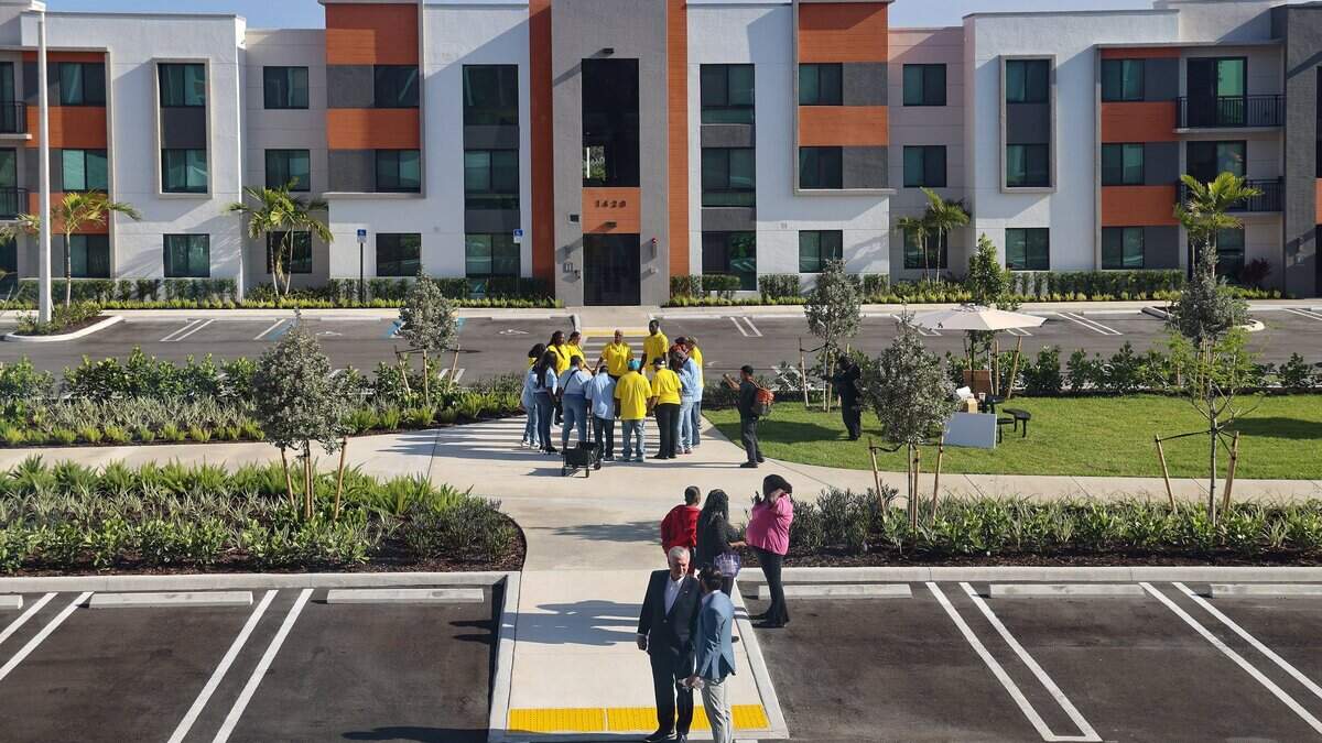 Liberty Square service providers and members of Coalition 305 gather in prayer prior to the start of the ribbon-cutting ceremony at Serenity of Liberty Square, a 193-unit Related Urban affordable housing project, phase four of the nine-phase redevelopment project, April 10, 2025.
