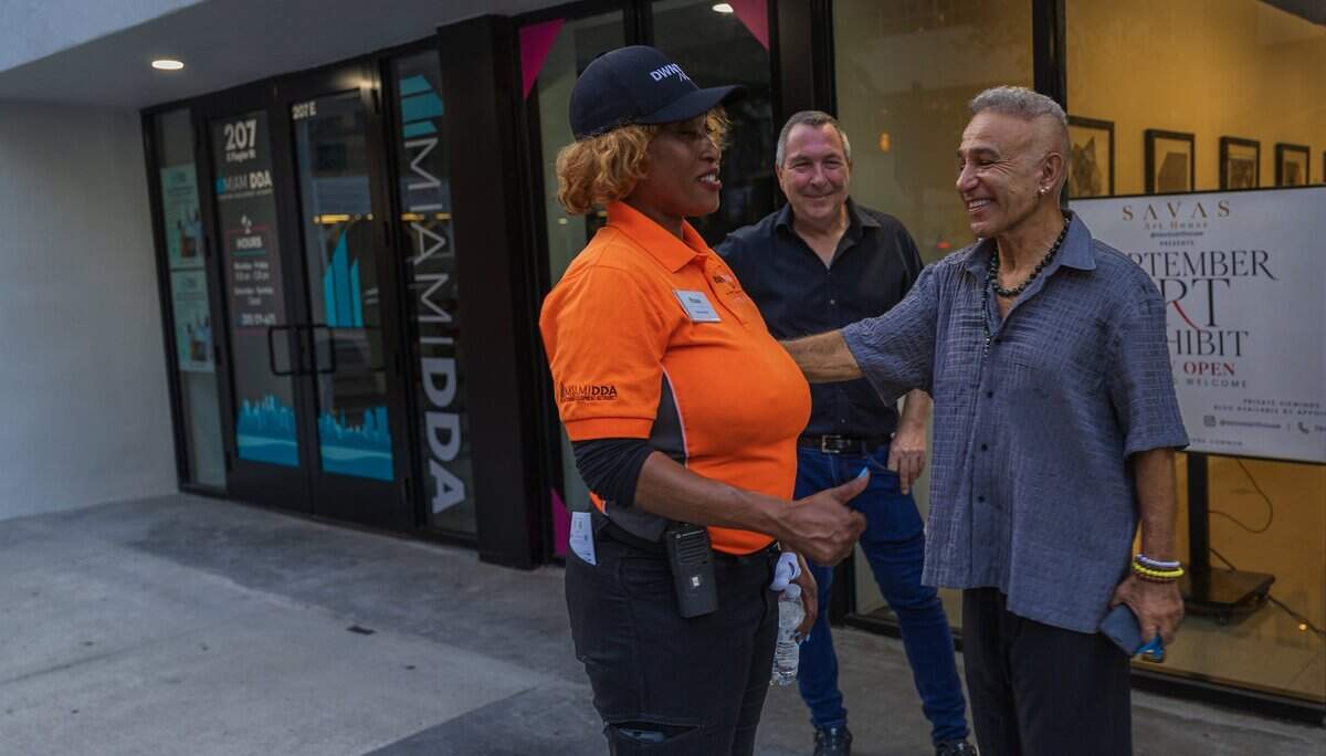 Billionaire real estate developer Moishe Mana greets Rose Lebron, one of the Downtown Development Authority’s downtown ambassadors, as he walks along Flagler Street.