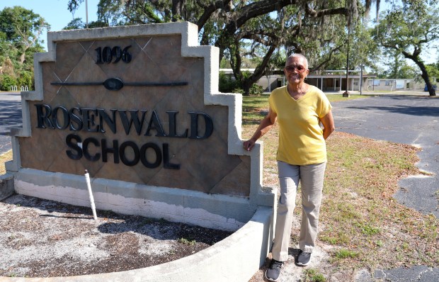 Cora Snead stood at the sign of the shuttered Rosenwald School in East Altamonte on April 25, 2024. Snead attended the school as a child and went on to teach kindergarten at it for many years before it was closed in 2011. (Rich Pope/Orlando Sentinel)