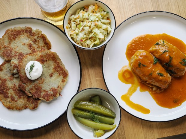Polish beer complements a slate of classic dishes from Pierogi One: potato pancakes and stuffed cabbage with sides of slaw and pickles. (Photo courtesy Lisa Wilk/TasteCookSip.com)