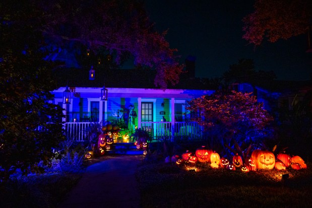 Shawn and Ryan Tofte's house illuminates with a cool blue hue and warm glowing jack-o'-lanterns at 1412 Ferris Ave. in Orlando on Oct. 12, 2026. (Patrick Connolly/Orlando Sentinel)