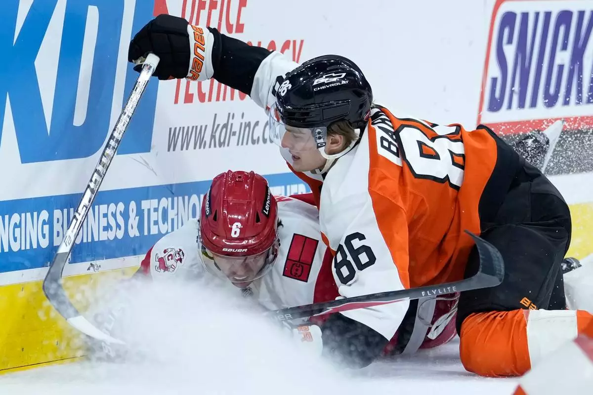 Philadelphia Flyers' Denver Barkey (86) and Carolina Hurricanes' Mike Reilly (6) collide during the second period of an NHL hockey game Sunday, Oct. 11, 2026, in Philadelphia. (AP Photo/Matt Slocum)