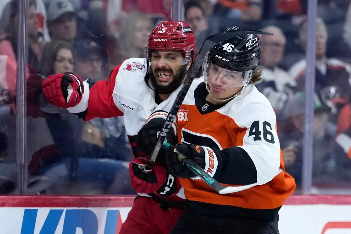 Philadelphia Flyers' Trevor Zegras, right, and Carolina Hurricanes' Jalen Chatfield collide during the second period of an NHL hockey game Sunday, Oct. 11, 2026, in Philadelphia. (AP Photo/Matt Slocum)