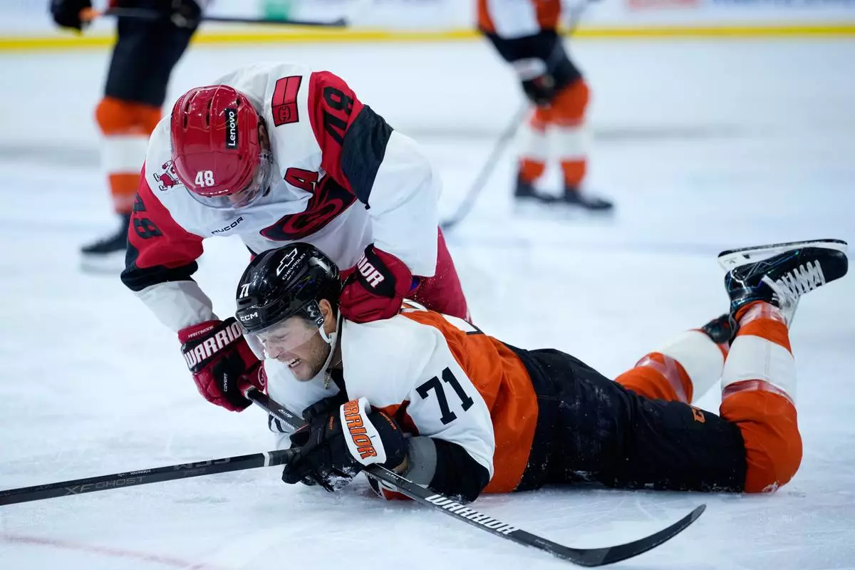 Carolina Hurricanes' Jordan Martinook, left, punches Philadelphia Flyers' Tyson Foerster during the second period of an NHL hockey game Sunday, Oct. 11, 2026, in Philadelphia. (AP Photo/Matt Slocum)