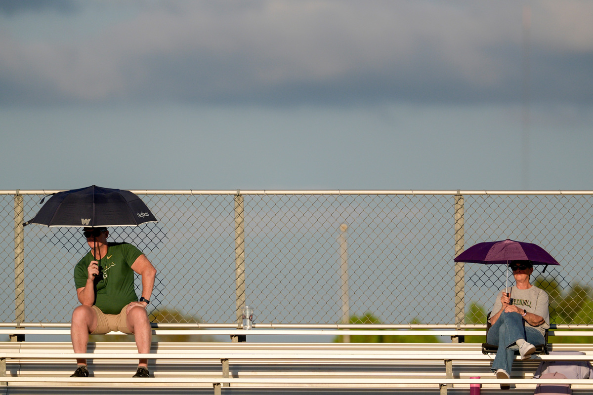 Fans hold umbrellas during a high school football game between Casady and Greenhill at Casady in Oklahoma City on Thursday, Sept. 10, 2026.