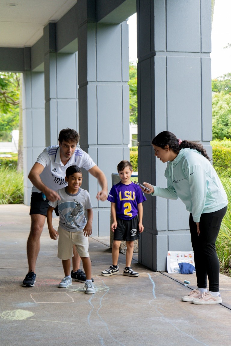 Brave Bunch counselors Claudia Marquez and Antonio Alves De Souza encouraging Christopher and Lucas to participate in an activity.