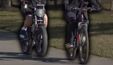 Two people ride e-bikes on a path.