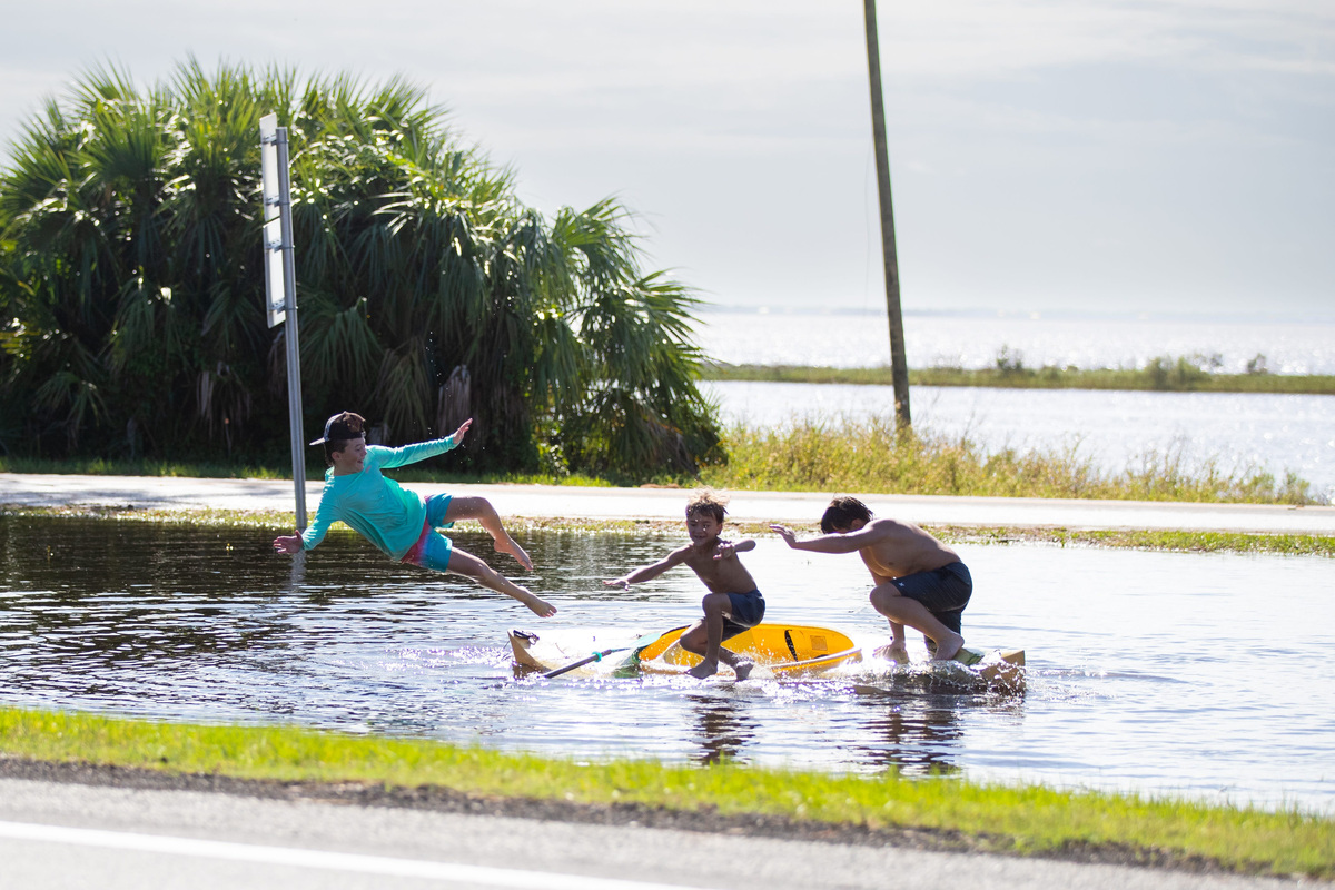 Children playing in a boat and swimming outside of the Marathon gas station in Eastpoint, Florida, on Saturday, Oct. 10, 2026, after Hurricane Isaias made landfall on the Gulf Coast.