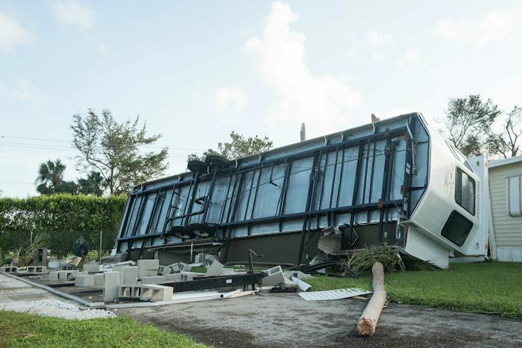 A mobile home rolled on its side with the bottom showing