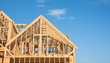 Wood framing is underway on a new single-family home under construction at a residential development site.