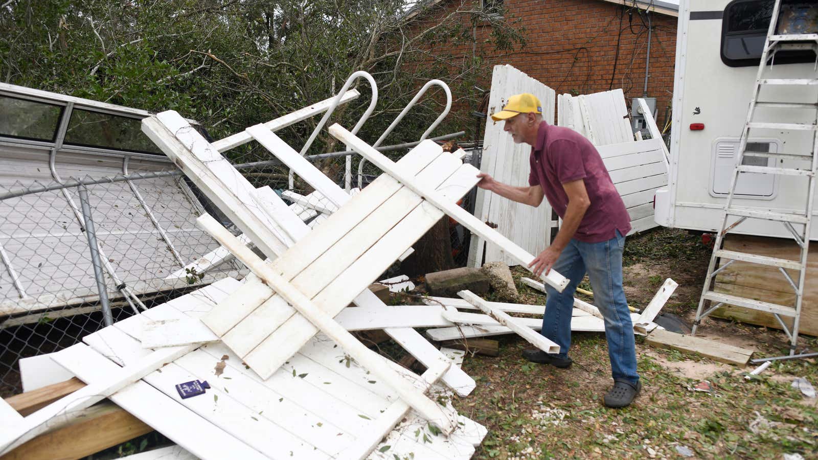 Curt Brown picks up debris left by Isaias around his RV home on Saturday, Oct. 10, 2026, in Milton, Fla.