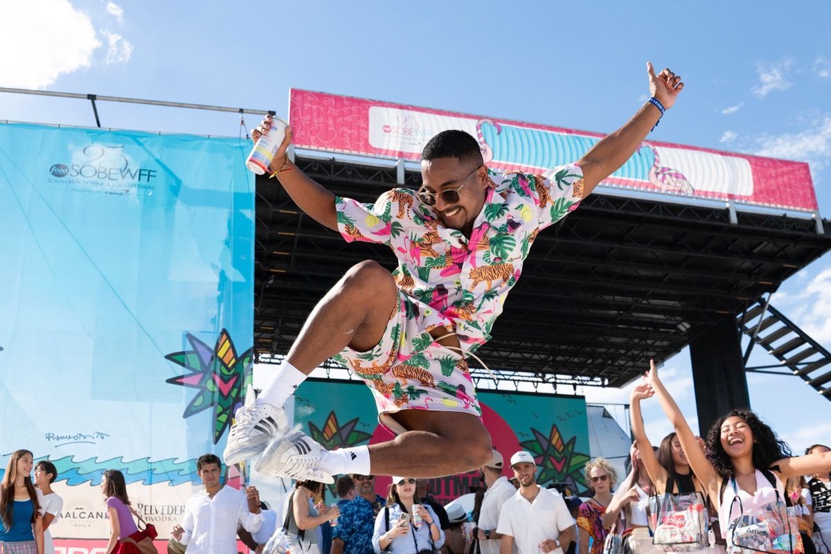 Festival-goer jumping with joy in front of the SOBEWFF stage on Miami Beach