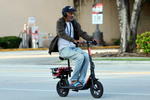 A man rides an e-scooter along Sunrise Boulevard in Fort Lauderdale on Oct. 8, 2026. (Amy Beth Bennett/South Florida Sun Sentinel)