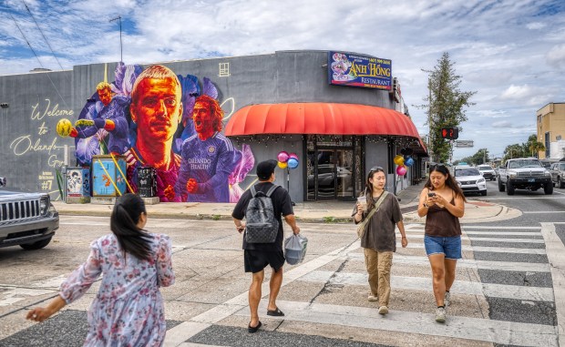 Pedestrians cross in front of the Anh Hong Vietnamese Restaurant on East Colonial Drive and North Mills Avenue, on Monday, October 5, 2026. The Mills50 neighborhood has become known as "Little Saigon" due to its many Vietnamese businesses. (Ricardo Ramirez Buxeda/ Orlando Sentinel)