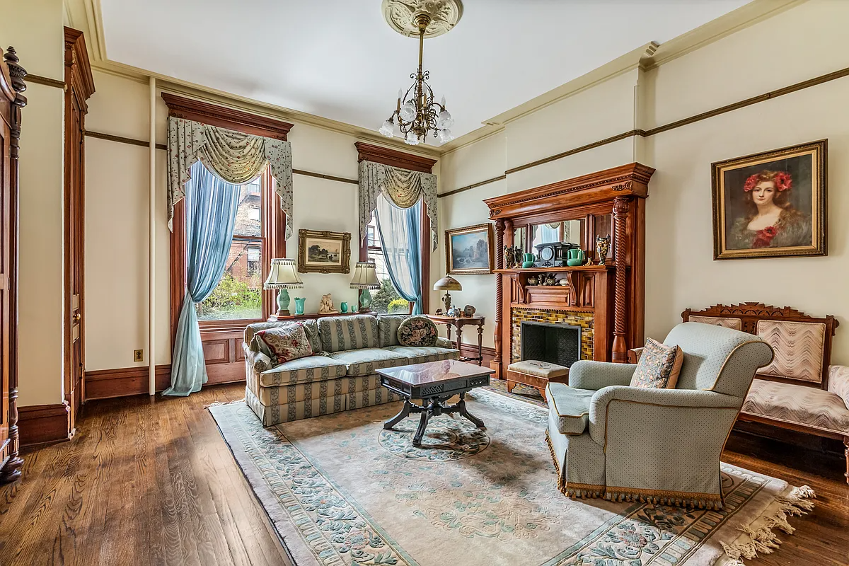 parlor with wood floor, woodwork, mantel, picture rail