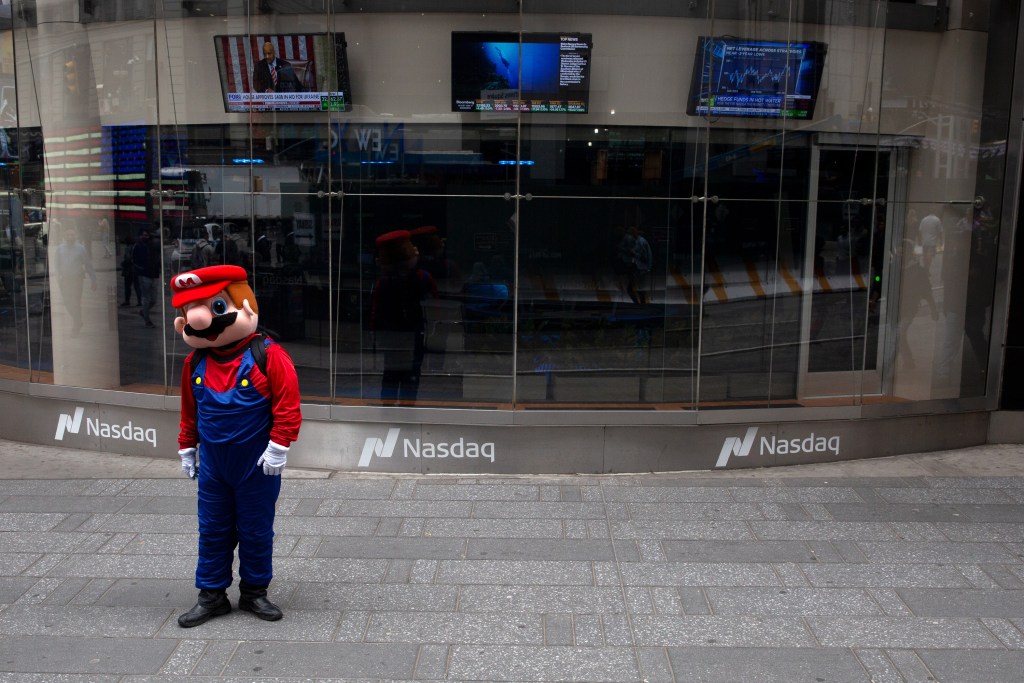 A Times Square worker waits for tourists to pass signs of bad economic news