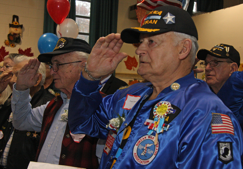St. Adalbert School hosts their Veteran's Breakfast and Assembly Day. Veterans Denny Pizzini, left and Drank Zielinski salute during the start of the assembly program. (Staten Island Advance/Irving Silverstein) Staff-Shot