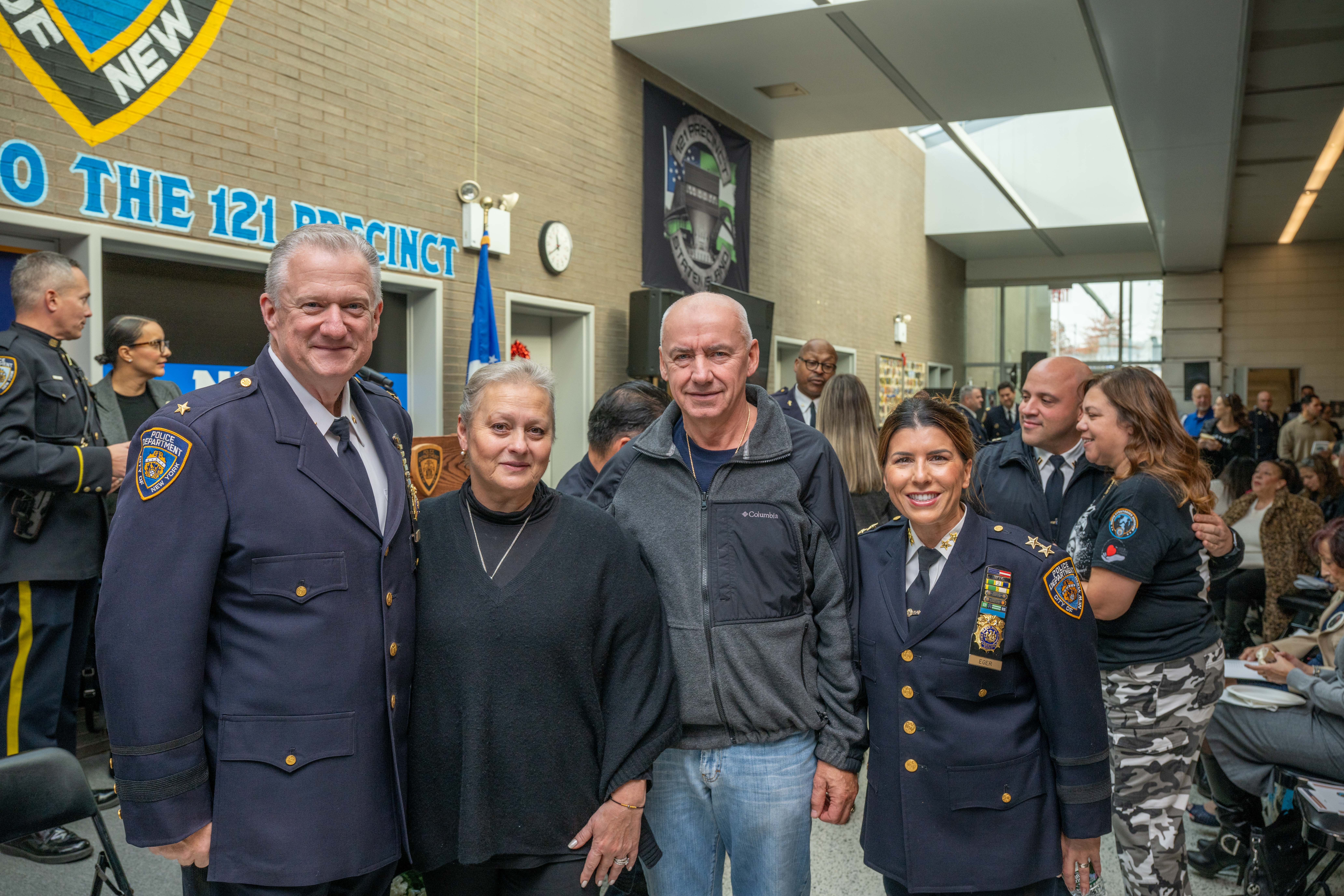 Assistant Chief Melissa Eger and Deputy Chief Terence Hurson pose with Tatyana and Leonid Timoshenko at the 121st Precinct on Saturday, November 15, 2025, in Graniteville for the 10th annual Staten Island Remembers, honoring fallen Staten Islanders who served in the New York Police Department. (Owen Reiter for the Advance/SILive.com)