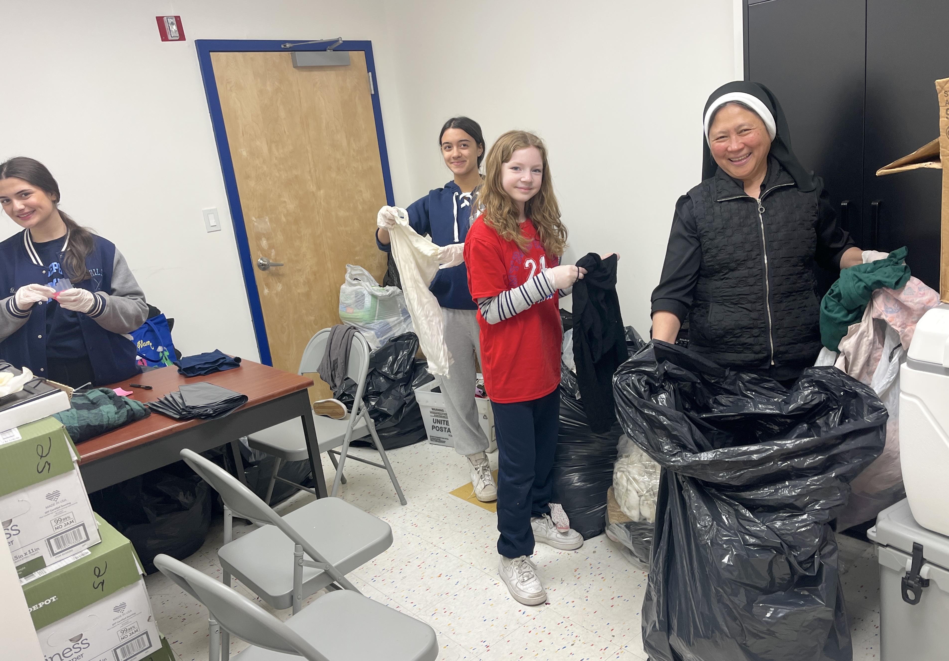Students volunteer their time sifting through donated clothing as well at Project Hospitality in Stapleton. (Advance/SILive.com | Jan Somma-Hammel)