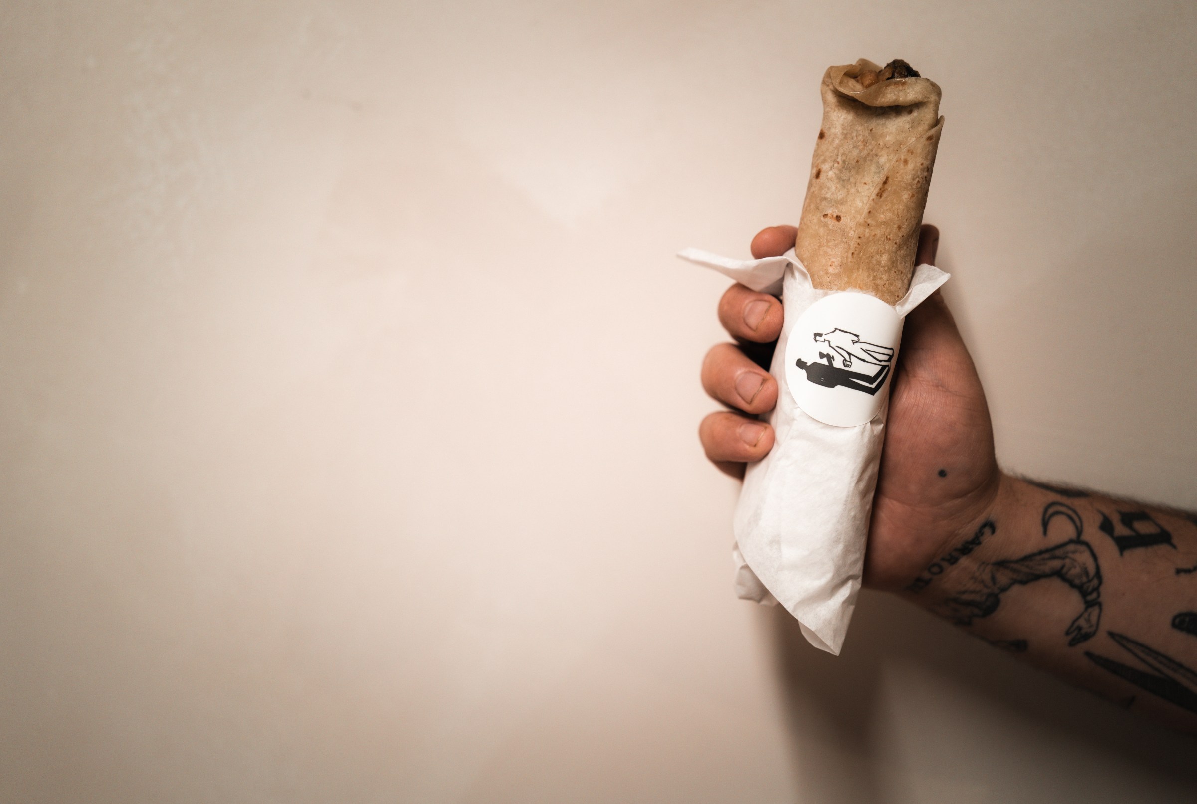 Someone holding up a burrito.