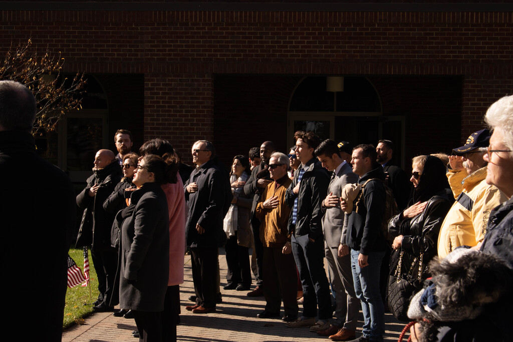 - Audience members saluting the flag during the Pledge of Allegiance. (Photo by Victoria Ifatusin)
