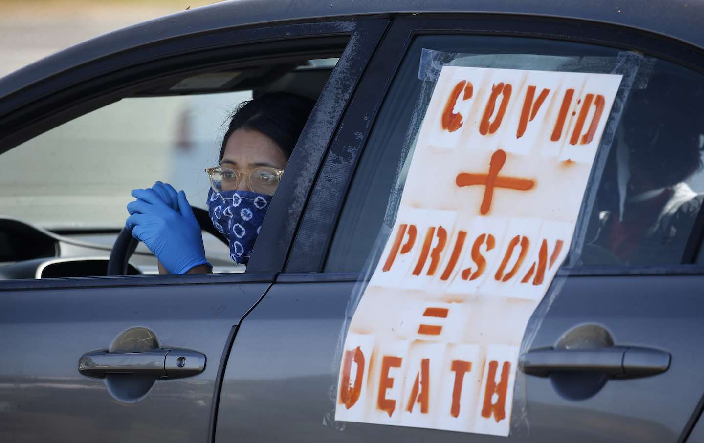 A demonstrator waits in her car before a rolling protest caravan departs for the west gate of San Quentin State Prison to demand more protection for prisoners against the coronavirus and Covid-19 in Larkspur, California, on May 9, 2020.