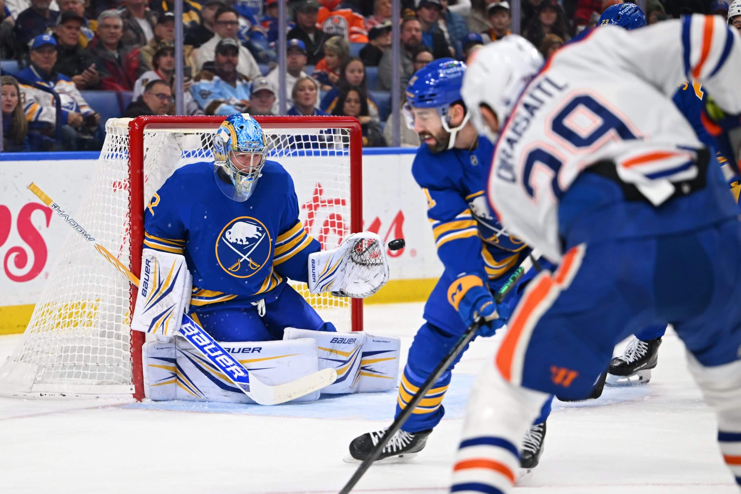 Buffalo goalie Colten Ellis makes a save on Edmonton's Leon Draisaitl, who's in the foreground to the right.