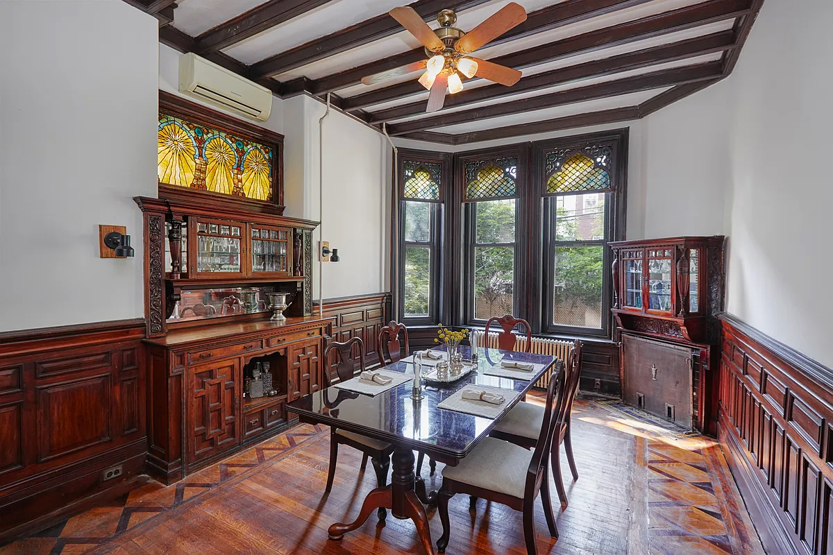 bed stuy - dining room with wood floor, wainscoting, built-ins, stained glass, beamed ceiling