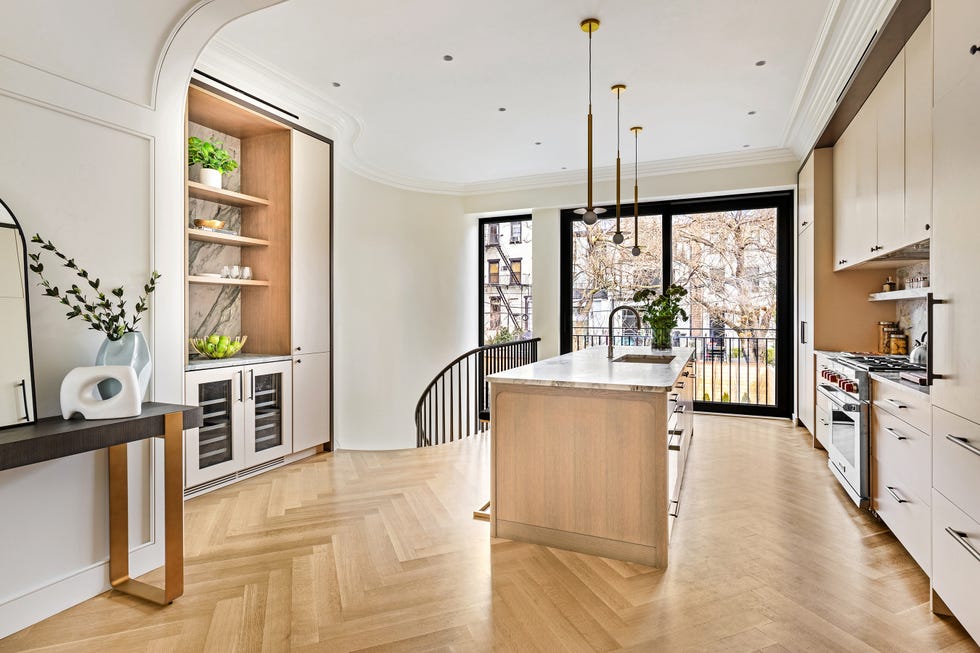 Modern kitchen featuring a central island and large windows.