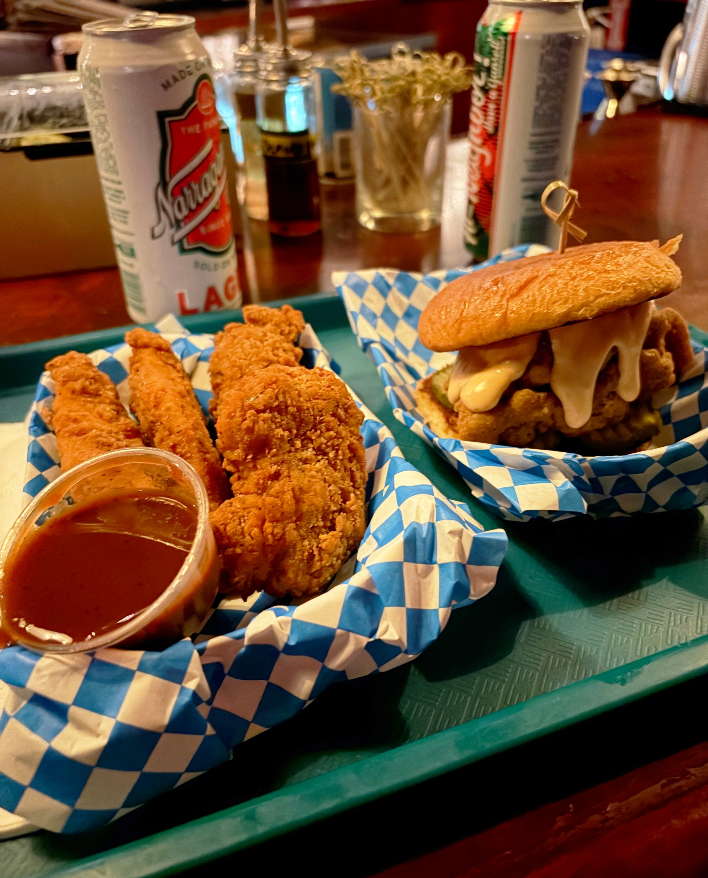 A tray with fried food next to a sandwich.