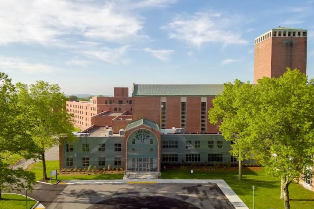 Shrub Oak International School building with a prominent tower and green trees.