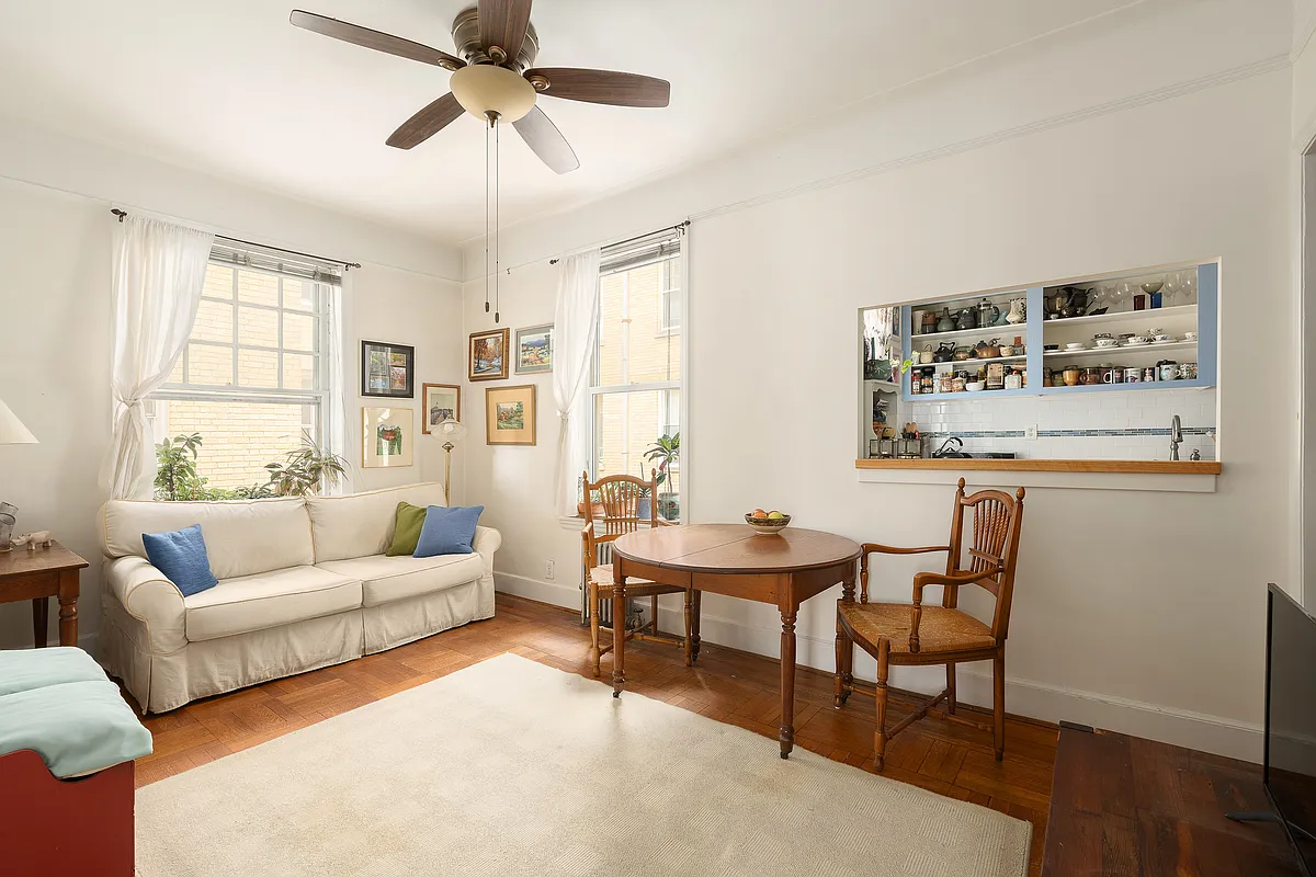 sunset park - living room with wood floor, white walls, picture rail, ceiling fan and passthru into kitchen