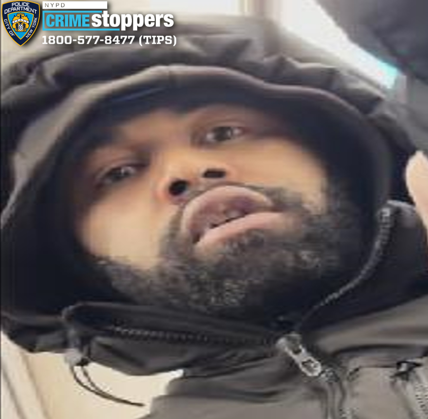 Close-up of a man with a beard and dark hooded jacket, identified as a person of interest by Crime Stoppers.